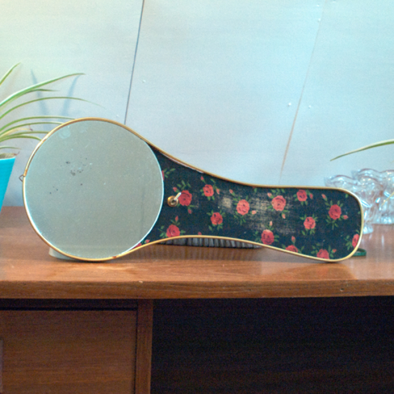 Vintage spiegel met borstel en bloemmotief